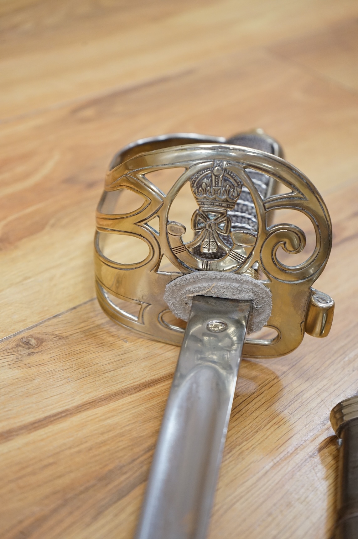 A post 1902, 1827 pattern Rifle Brigade officer’s dress sword, with regulation blade with traces of edge decoration, regulation nickel guard with crown strung bugle and wire bound fish skin covered grip, in its steel sca